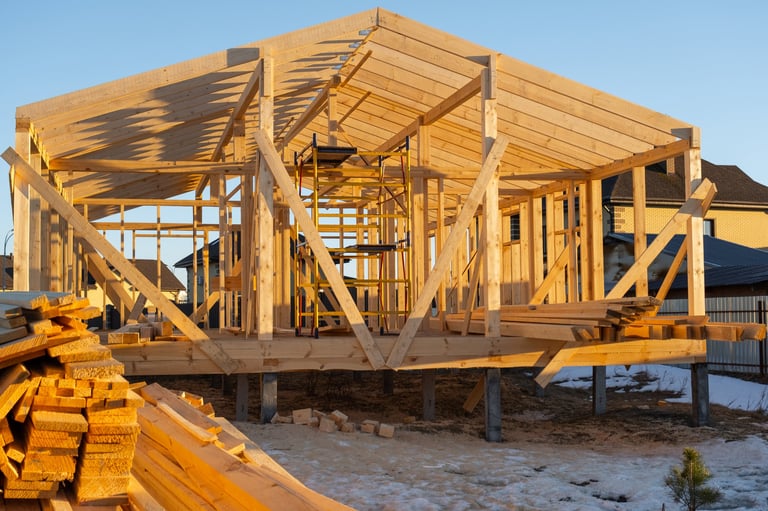 Frame house assembling, wooden skeleton, beams, posts in place, bracing elements, foundation support, modern carpentry, site construction progress, installation.